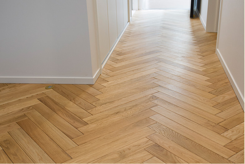 床は空間デザインの大切なポイント。木片を“矢羽状”に敷き詰めた“ヘリンボーン”スタイルは無垢材にこだわり。